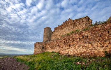 View of the medieval walled castle of Almoacid in Toledo, Castilla la Mancha, Spain, with morning light and beautiful clouds