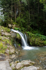 Mountain waterfall in the forest. Green nature. Lake water Kamianka Carpathians river