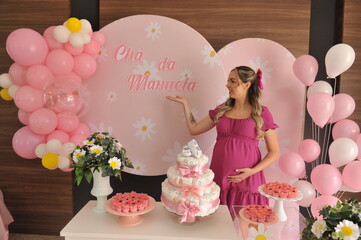 Mulher gestante em chá de menina rosa 