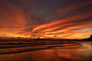 Dramatic sunset with orange sky and clouds on Ao Nang beach in Krabi, Thailand