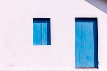 white wall with blue door and window