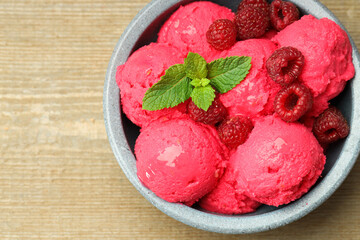Delicious raspberry sorbet, fresh berries and mint in bowl on wooden table, top view