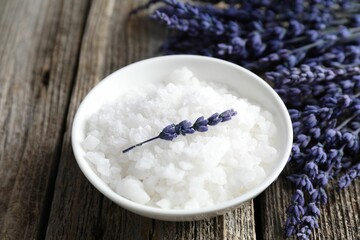 Natural sea salt and lavender on wooden table, closeup