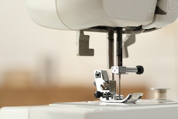 Sewing machine with thread on blurred background, macro view
