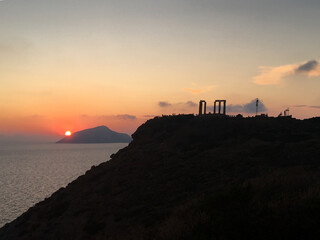 Greece Cape Sounio. Ruins of an ancient temple of Poseidon, Greek god of the sea, shot before sunset with sea view. Tourist landmark of Attica, Sounion, Greece