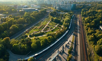 Fototapeta premium Aerial view of urban landscape with park, railway, and buildings