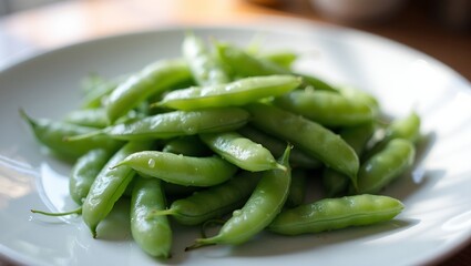 Fresh green snap peas on white plate glistening with water droplets in soft natural light