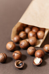 Whole macadamia nuts with cuts in the shell, ready to eat. Close-up view of the textured surface of the nuts.