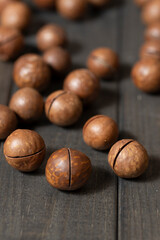 Whole macadamia nuts with cuts in the shell, ready to eat. Close-up view of the textured surface of the nuts.