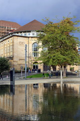 Freiburger Theater spiegelt sich im Synagogenbrunnen