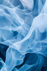 Obraz premium A blue and white image of a fabric with a blue flame. The image has a dreamy, ethereal quality to it, with the blue and white colors blending together to create a sense of movement and fluidity