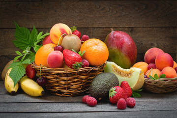 Bunch of juicy delicious organic fruits in basket on table