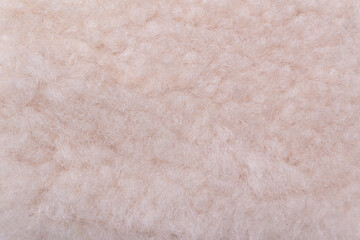 A close-up of soft, fluffy genuine beige wool. Top view. The photo showcases the warm, cozy texture of this material, perfect for creating comfortable and exceptionally warm items.