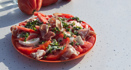 Sliced with prosciutto, mozzarella and tomatoes on the table