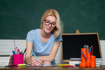 Funny female young teacher in the classroom. Teacher is skilled leader. Portrait of a female student in university. Young teacher. Young serious female Student studying in school.