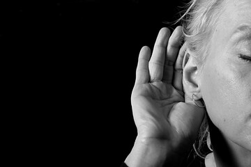 deaf woman suffering from deafness and hearing loss on gray background with people stock image...