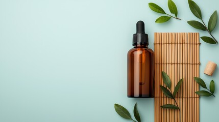 Essential oil bottle with green leaves and bamboo mat on a serene background.