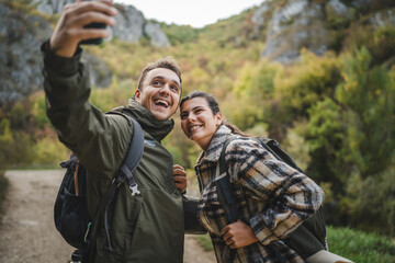 happy couple take a self portrait or video call on hiking