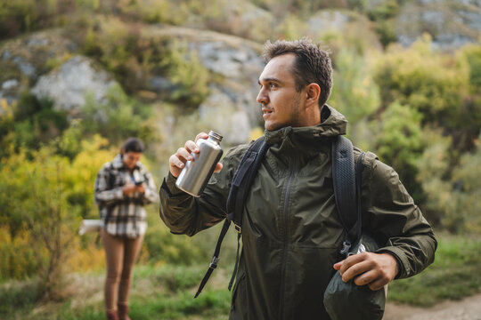 Adult tired man hiker rest from hiking and use the moment to hydrate