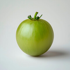 A single, green tomato on a white background.