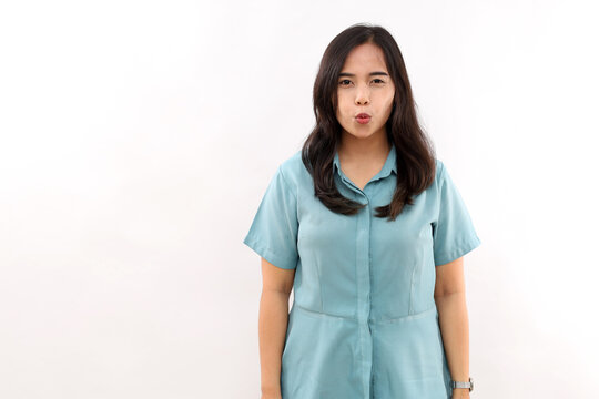 Beautiful Asian woman, healthy skin, keeps lips folded, awaits for kiss, has flirty mood. Facial expressions concept against white background