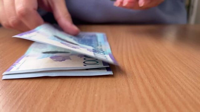 Horizontal 4K video close up. Cash money. Female hands count paper banknotes 10000 tenge of Kazakhstan. Concept of currency exchange, credit, bank, debt, loan, salary, bribery, tax. Bill. Bank note