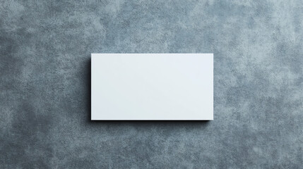 Blank business card on a textured gray background, ideal for mockups or creative designs.