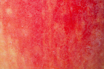 Red and yellow apple texture with water drops as background.