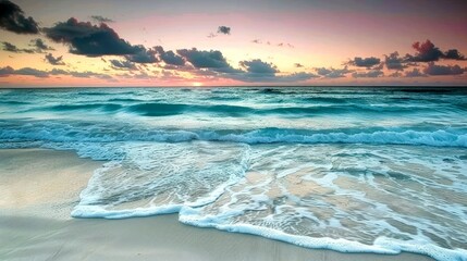 A serene beach scene at sunset, showcasing waves and a colorful sky.