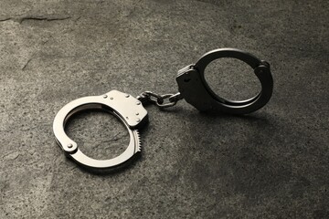 Classic chain handcuffs on grey table, closeup