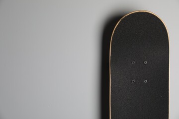 Modern skateboard on light grey background. Space for text © New Africa
