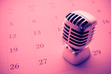 Classic retro microphone on blank calendar background color fun tone. Concept of agenda, appointment or reminder in live podcast, meeting, concert, seminar, advertisement, learning, etc.