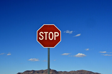 Surreal Lone stop sign and distant mountains and clouds, Highway 6, Nevada 