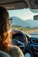 a woman with glasses  seen from behind, driving a car.