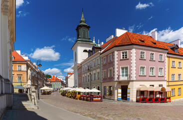 Street in the old town with historical buildings, colorful facades, church and street cafes, Warsaw, Poland