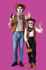 Little boy with candies and his father dressed for Halloween as cowboys on purple background