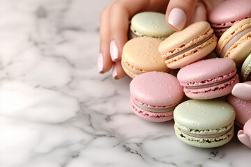 woman's manicured hands arranging pastel-colored macarons on marble surface