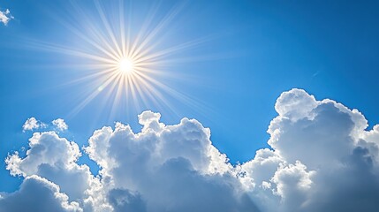 A bright sun shines through fluffy white clouds in a clear blue sky.