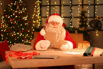 Santa Claus with letters at home on Christmas eve