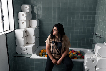 Mujer latina sentada en una tina de baño con pelotas de colores