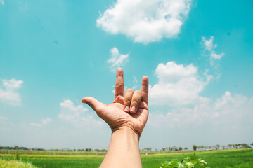hands reaching out to the sky in devil horn gesture
