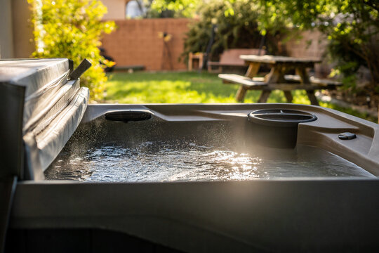 Hot tub with bubbling water in a backyard during sunny afternoon