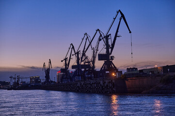 Obraz premium silhouette of port cranes at night