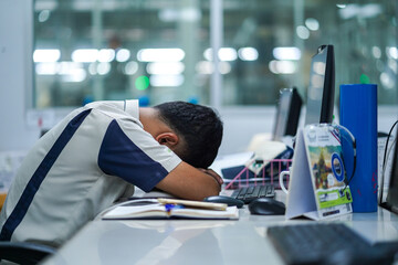 Salary man is sleeping on the desk after working hard. Officer is NAP in working time.