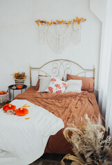 Cozy autumn-inspired bedroom with warm colors and decorative elements on the bed