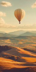 Fototapeta premium Balão de ar quente flutuando sobre uma paisagem rural