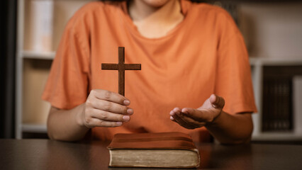 One women bring the bible and after that shen starting to pray and worship with all her heart.