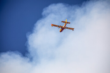 fire fighting plane flying through smoke