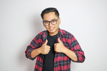 A happy Filipino man giving a rousing thumbs up in approval. In a white shirt and gray windbreaker....