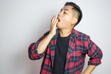 young Asian man with yawn face and sleepy on white background